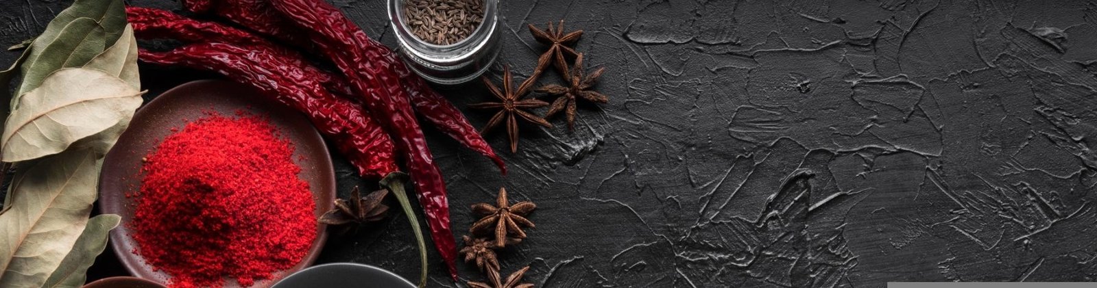 Indian spices arranged on a dark slate